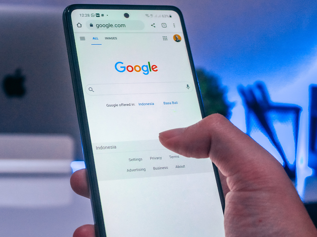 A person holding a phone with Google pulled up.
