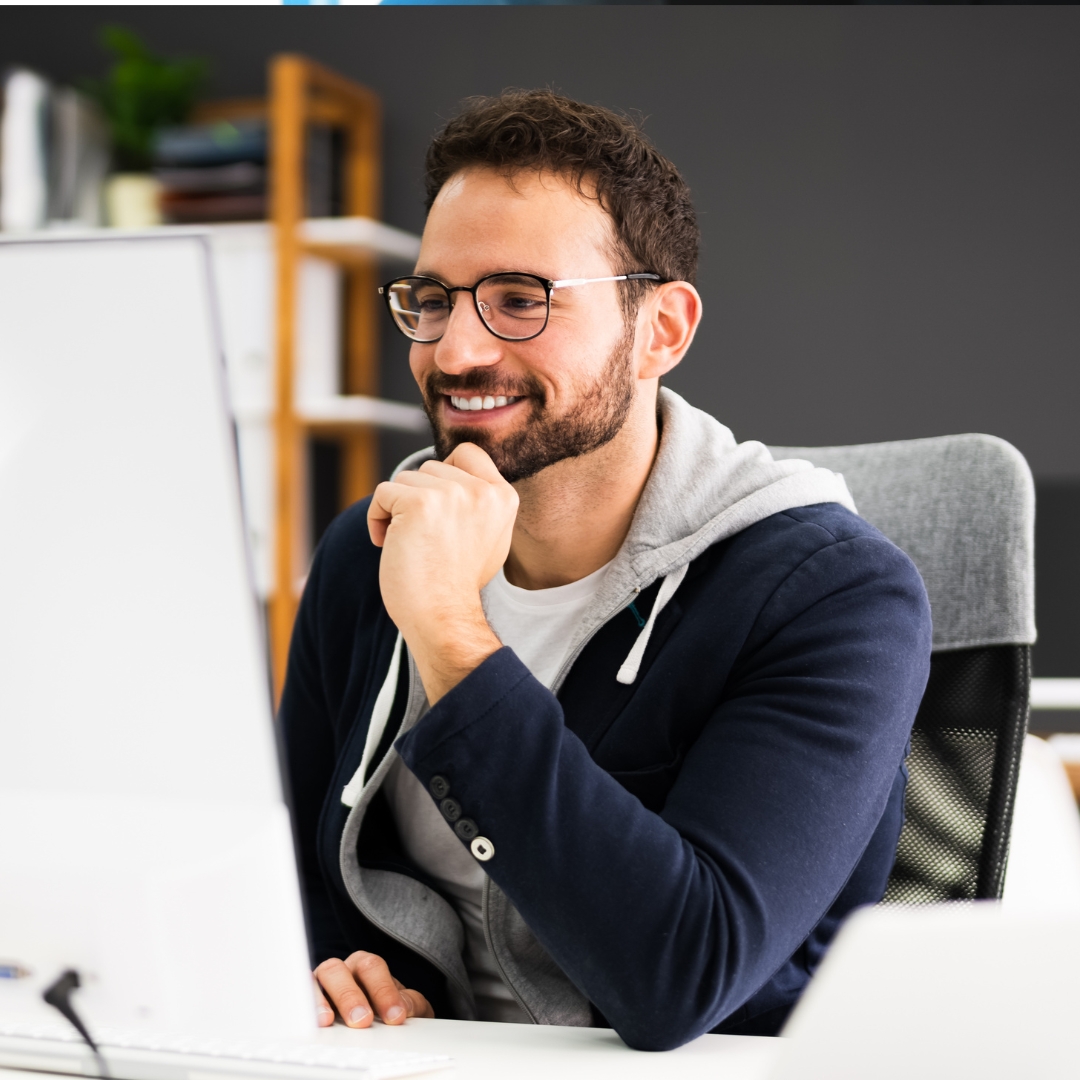 man smiling working at a computer