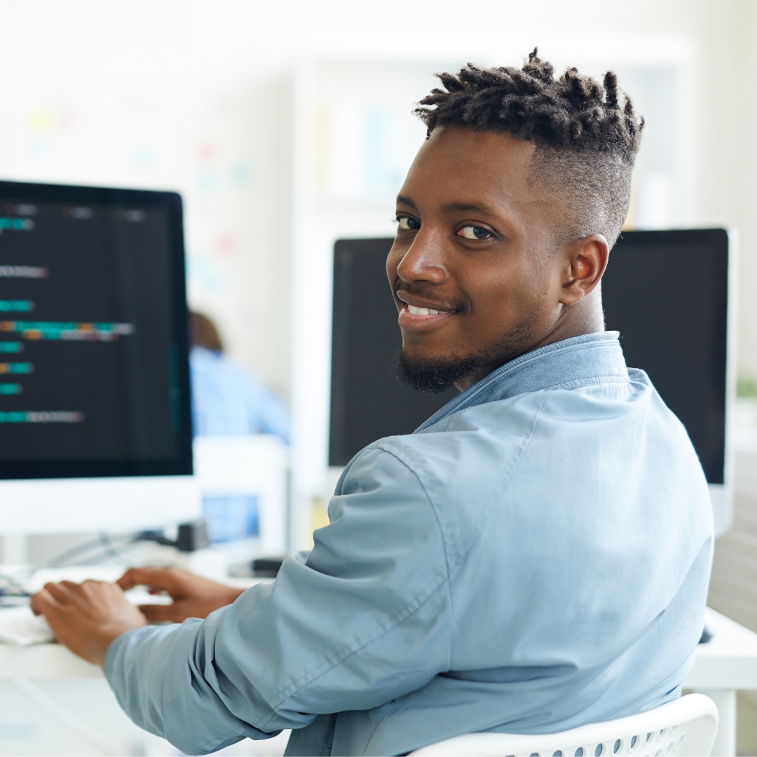 man smiling working at a computer