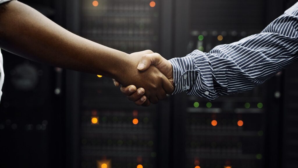 shaking hands over IT equipment